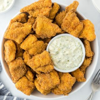 catfish nuggets on a white platter with dipping sauce