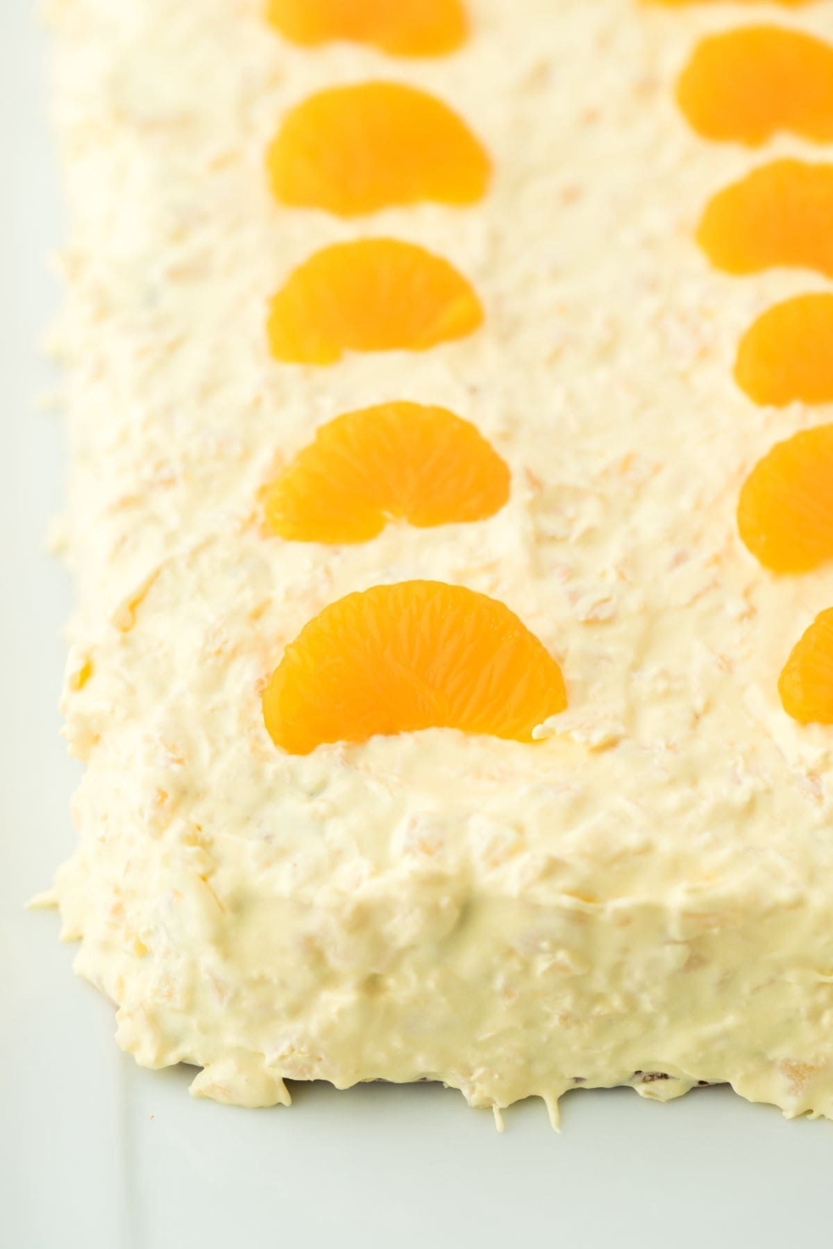 Closeup of pig pickin' cake, showing the fluffy frosting and the mandarins on top