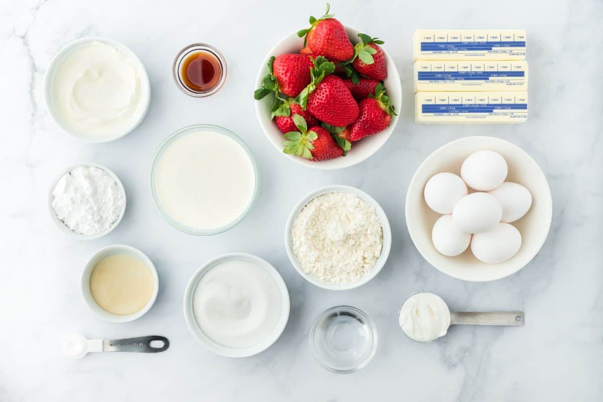 Overhead shot of ingredients to make strawberry shortcake pound cake on a white surface before mixing