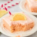 pink lemonade cake slice on a white plate with fork cutting through