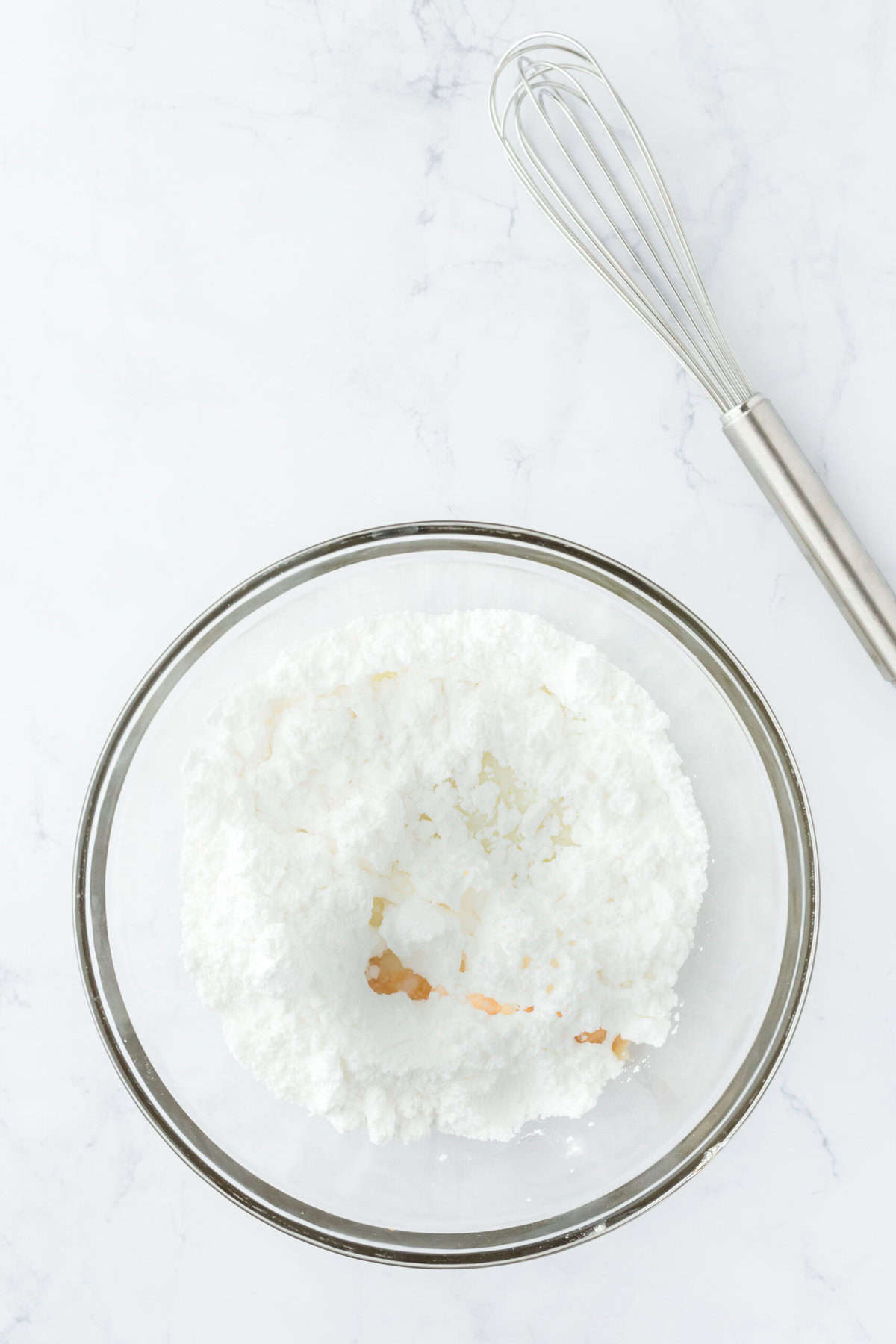 Confectioner's sugar and milk being mixed together in a small bowl to make glaze