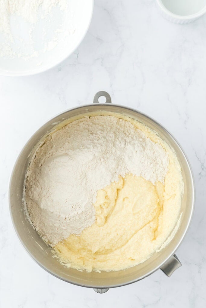 Flour added to finish up pound cake batter on white countertop