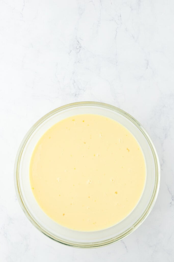 Eggs added to a white chocolate bread pudding custard mixed together