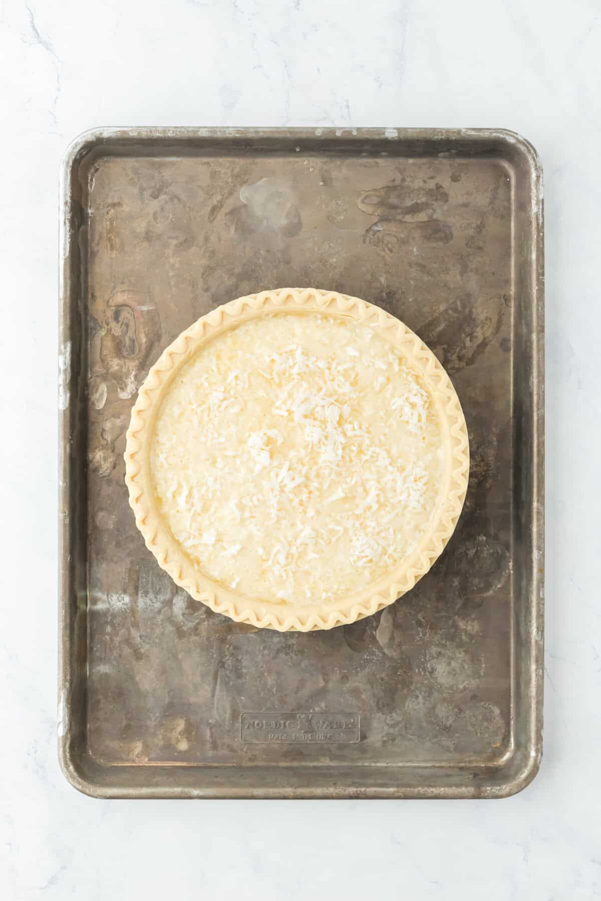 Custard egg custard added to pie crust on sheet pan.