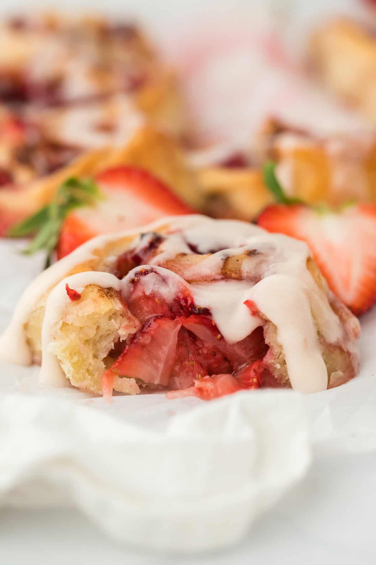 An easy strawberry cinnamon roll cut into with strawberries there