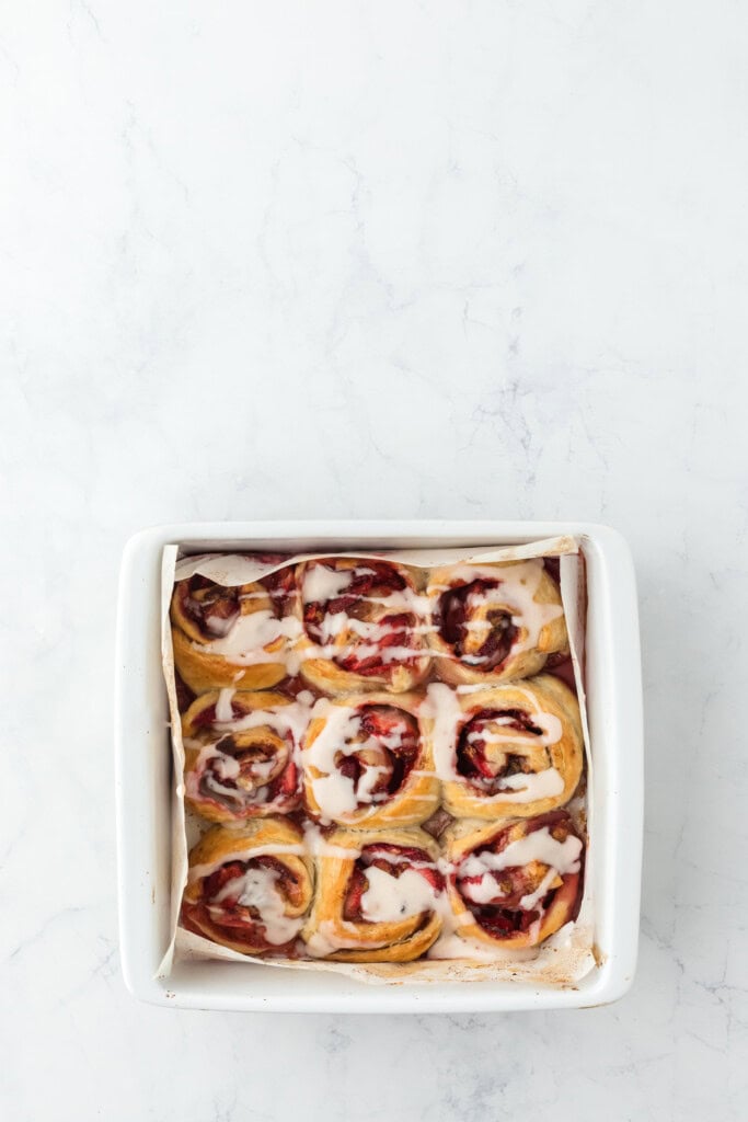 A white icing drizzled on top of easy cinnamon rolls with icing