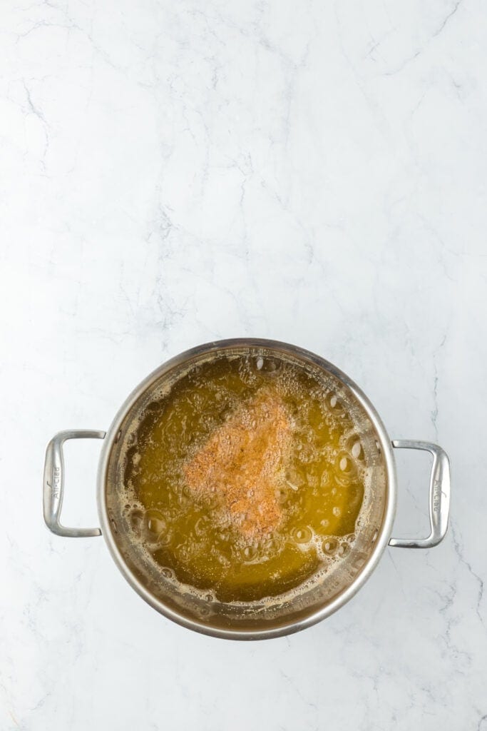 Catfish being fried in hot oil in pot