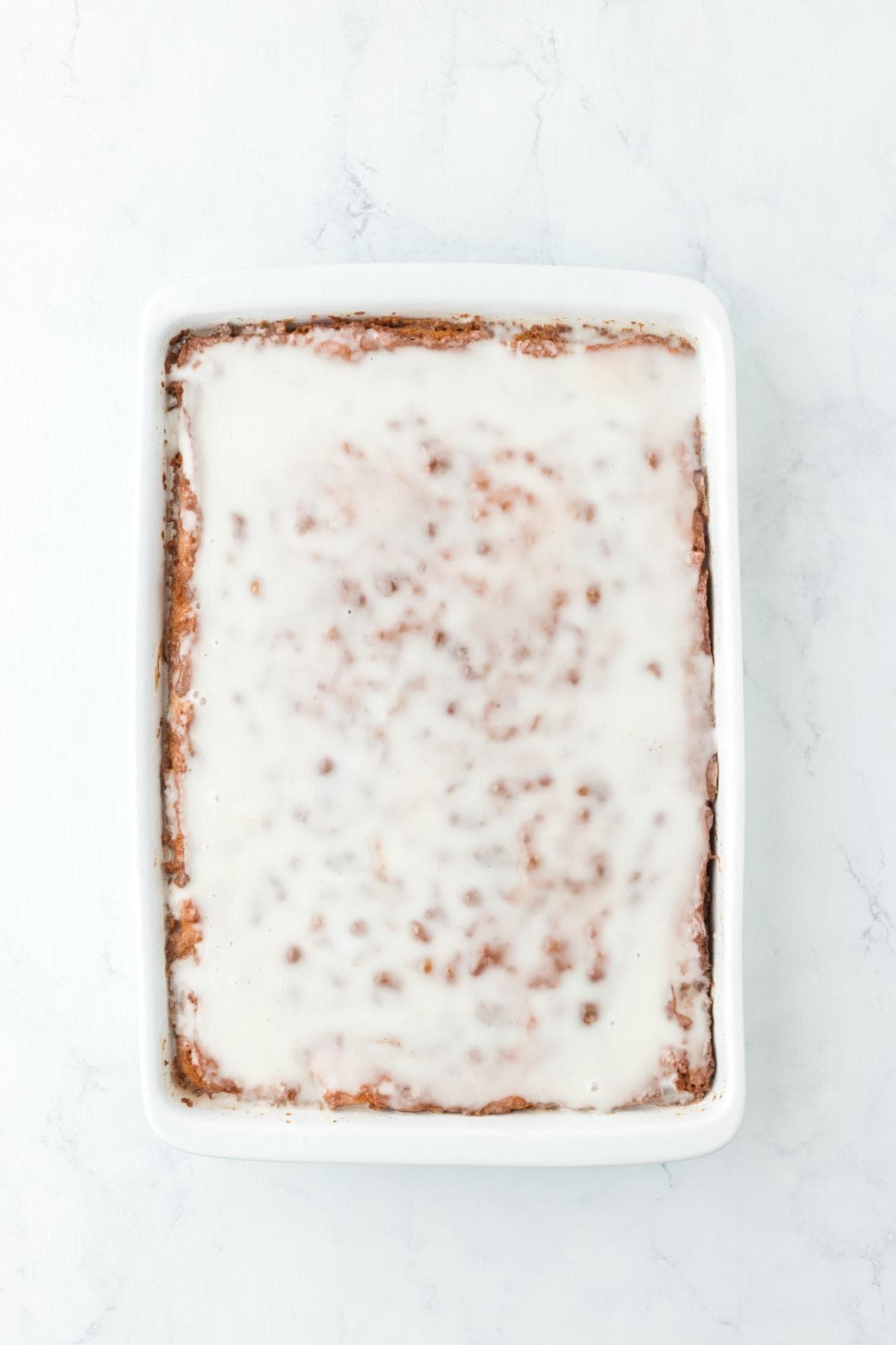 Honey bun cake in pan topped with white glaze
