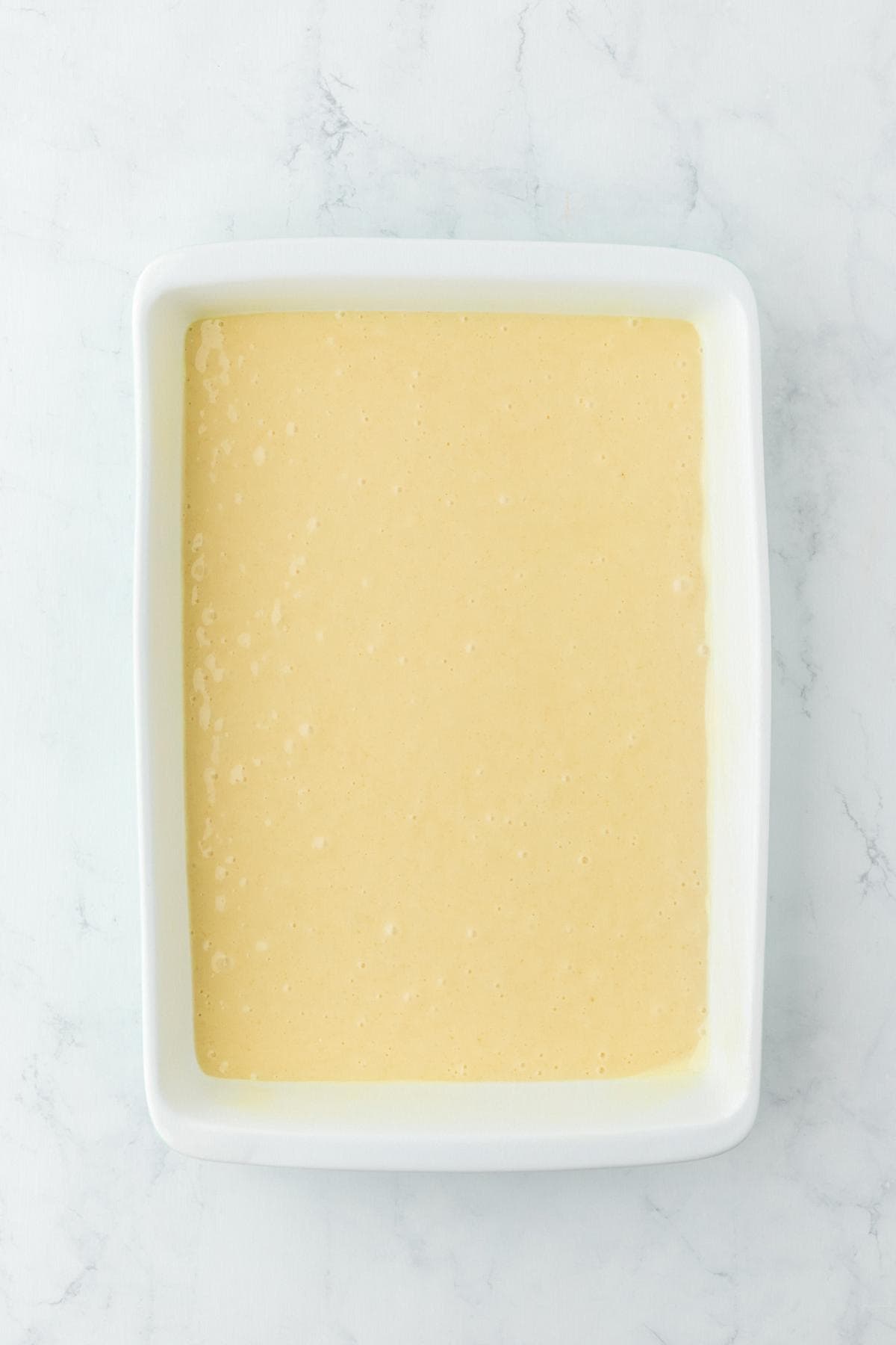 Cake batter poured into square baking dish
