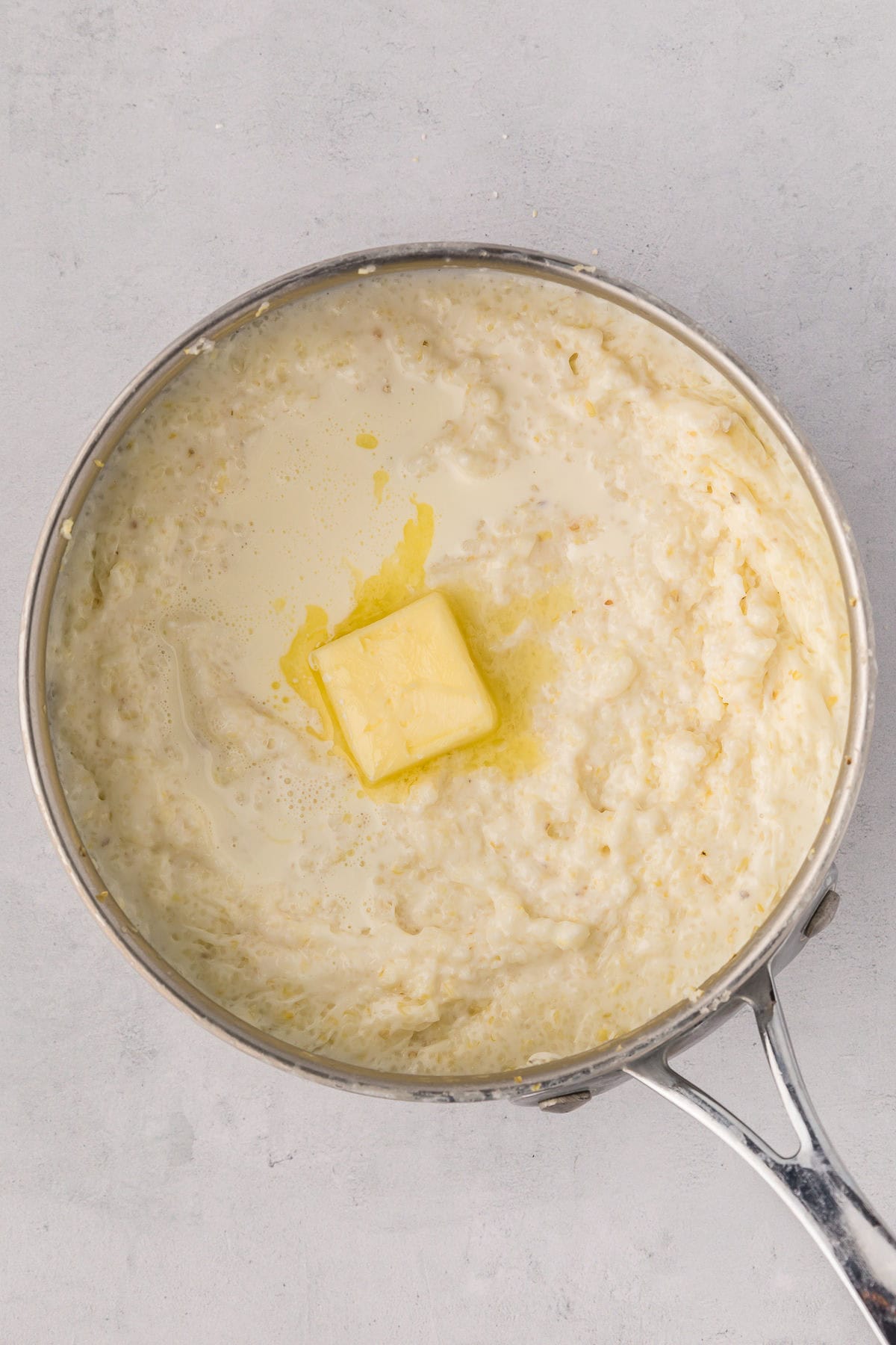 A pat of butter and splash of cream melting into the hot, fluffy grits