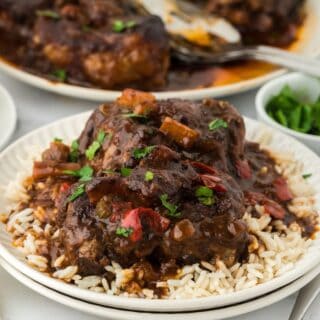 Jamaican oxtails on a white plate being served