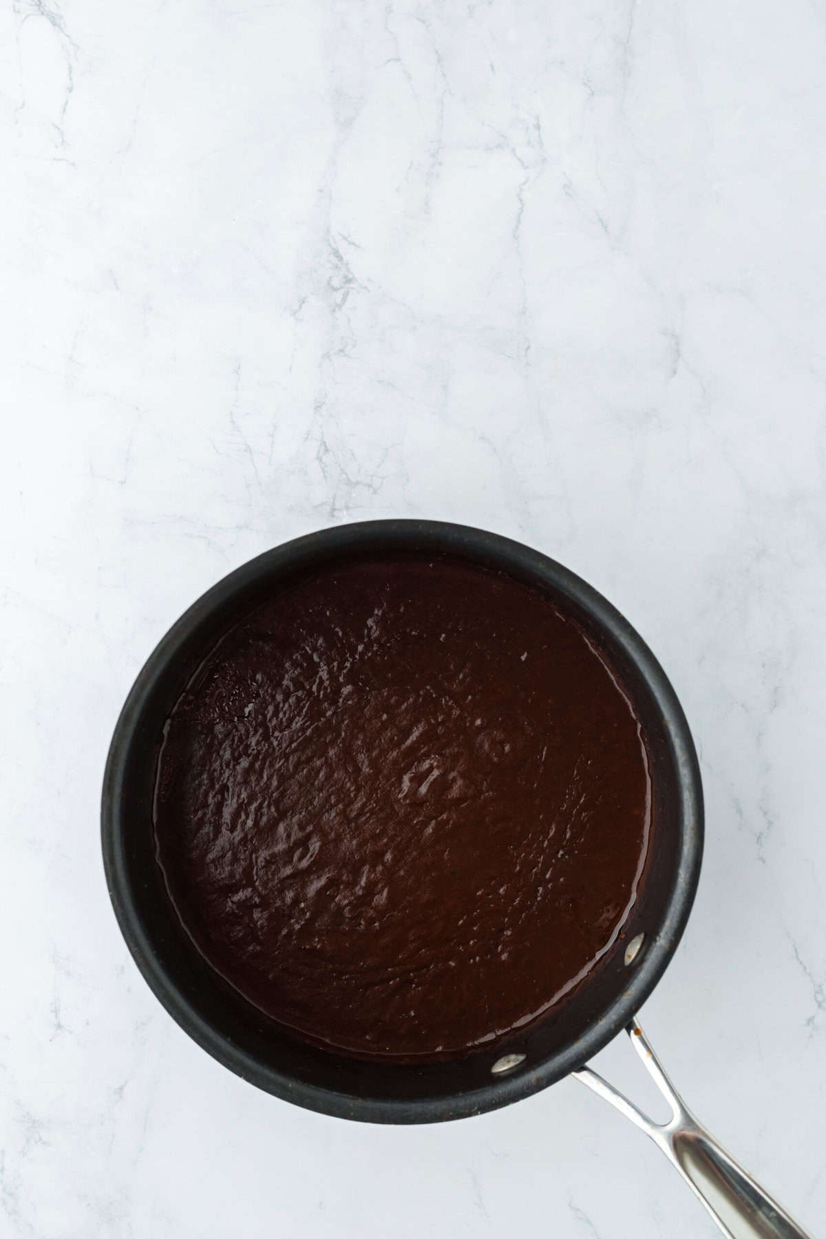 Simmering oxtail sauce in a pot on white background