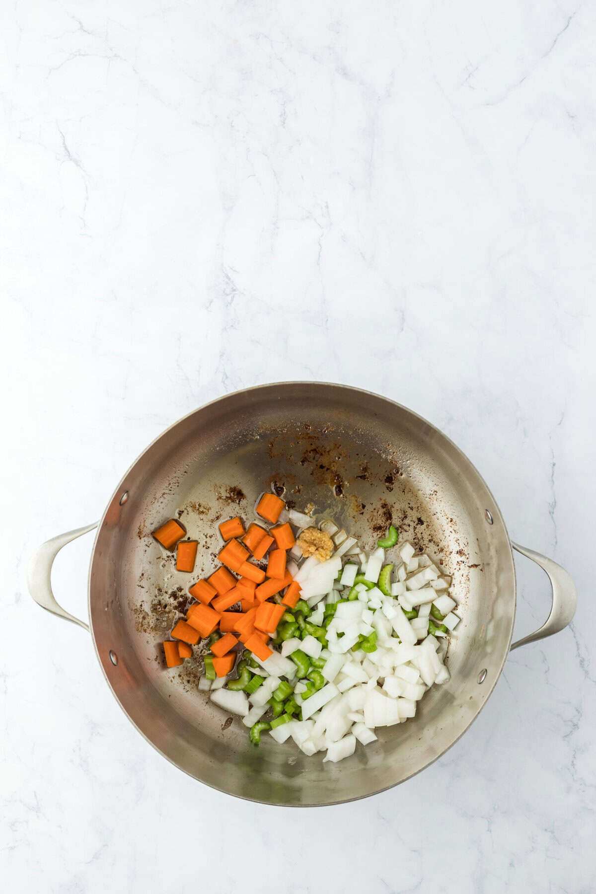 Veggies cooking in a pan with olive oil on white background