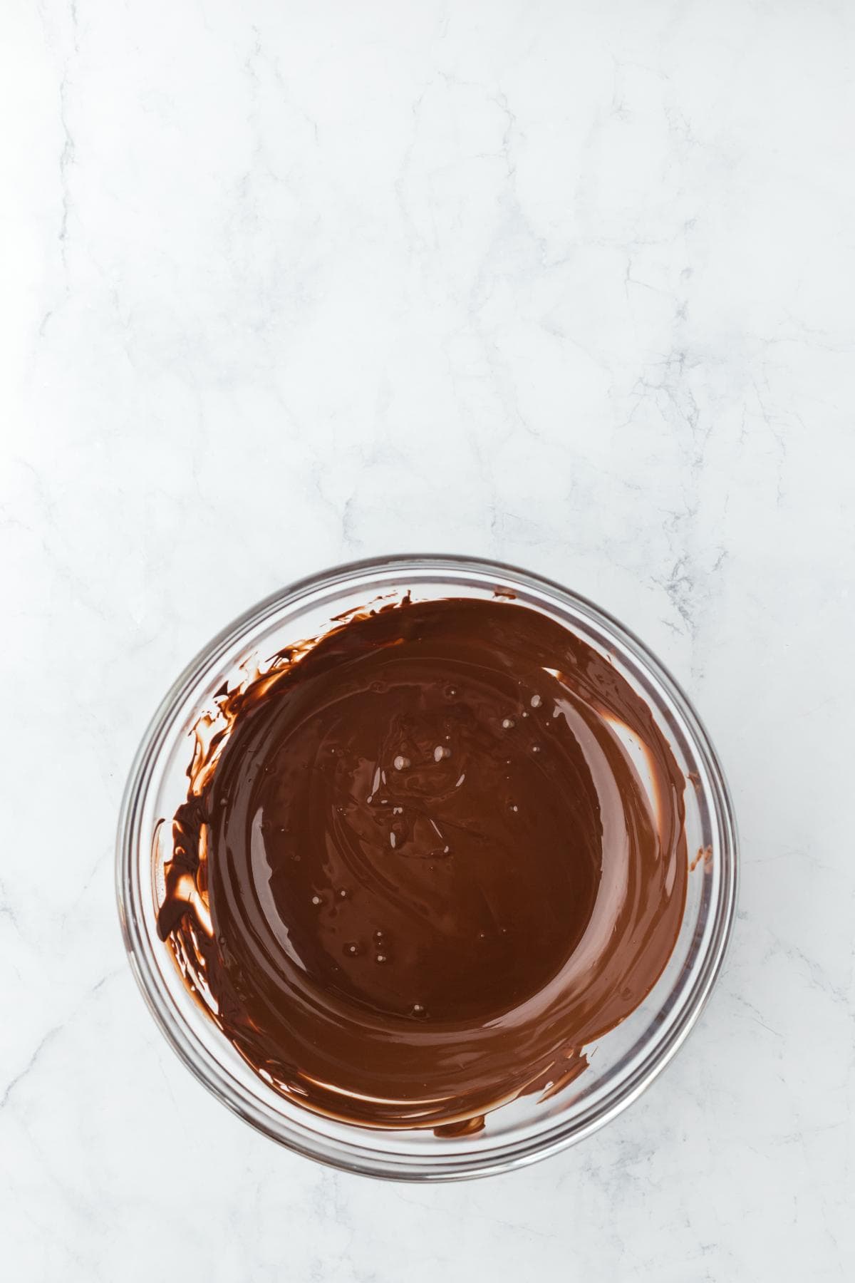 A bowl of smooth, melted dark chocolate ready for spreading