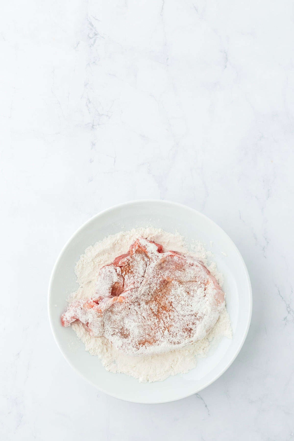 Dredged pork chops on a white plate