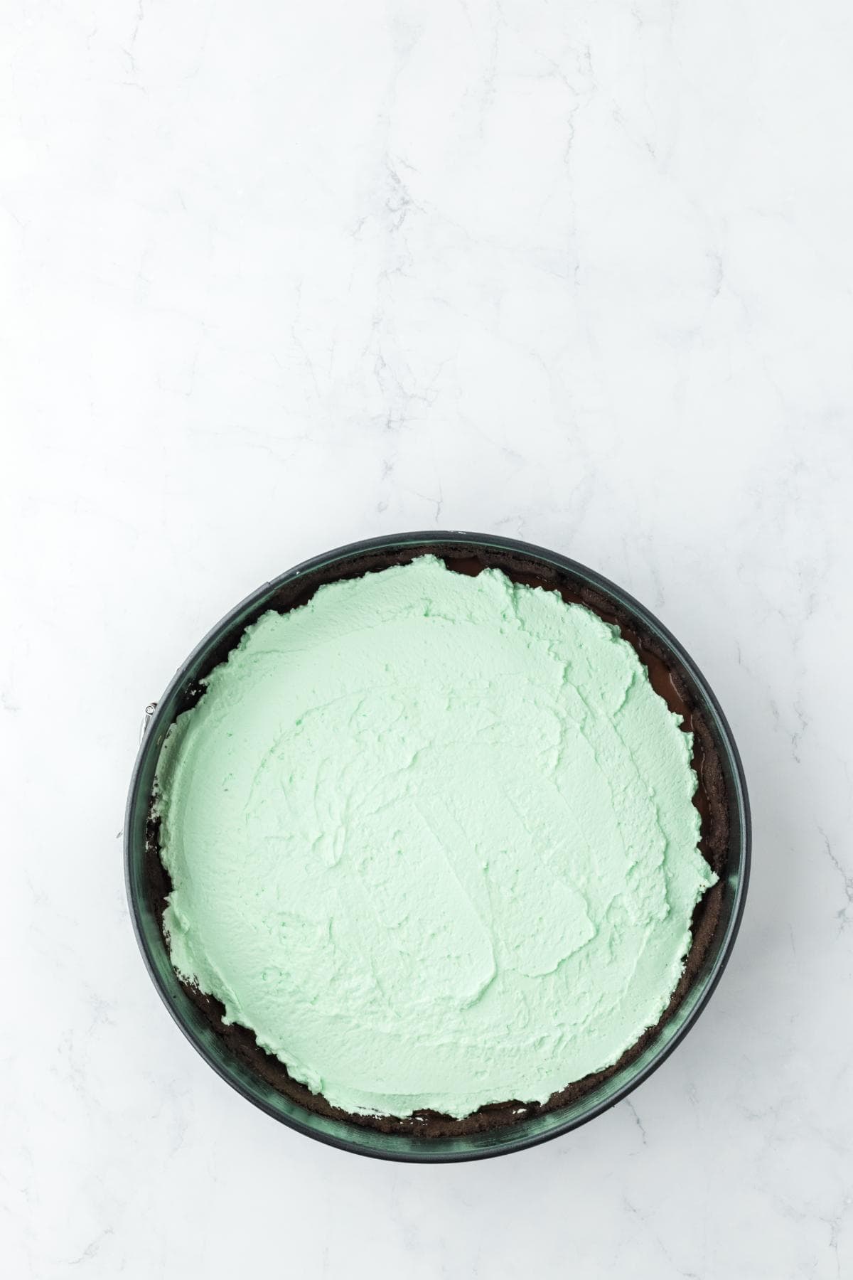 Mint whipped cream spread over the mint chocolate cream pie