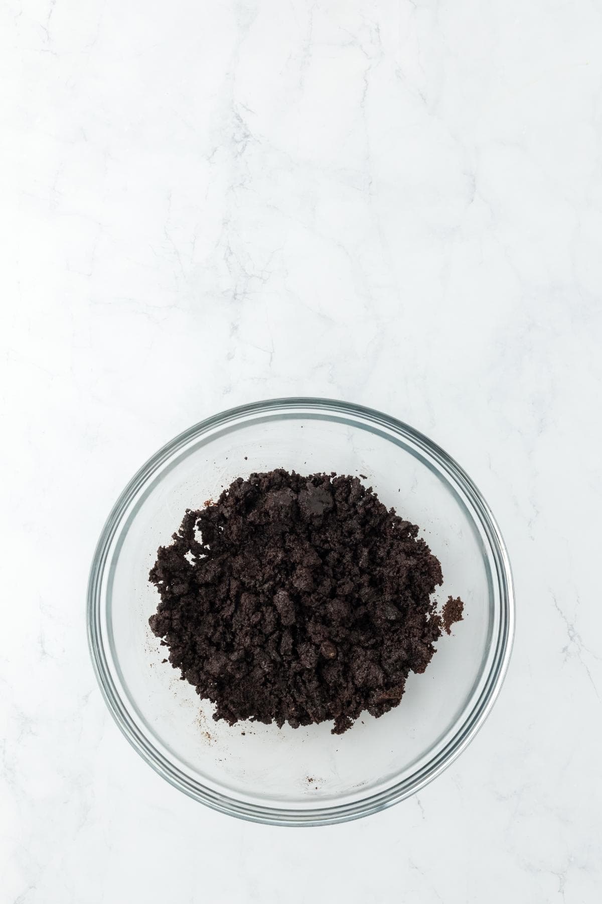 Crushed Oreo crust mixture in a glass bowl