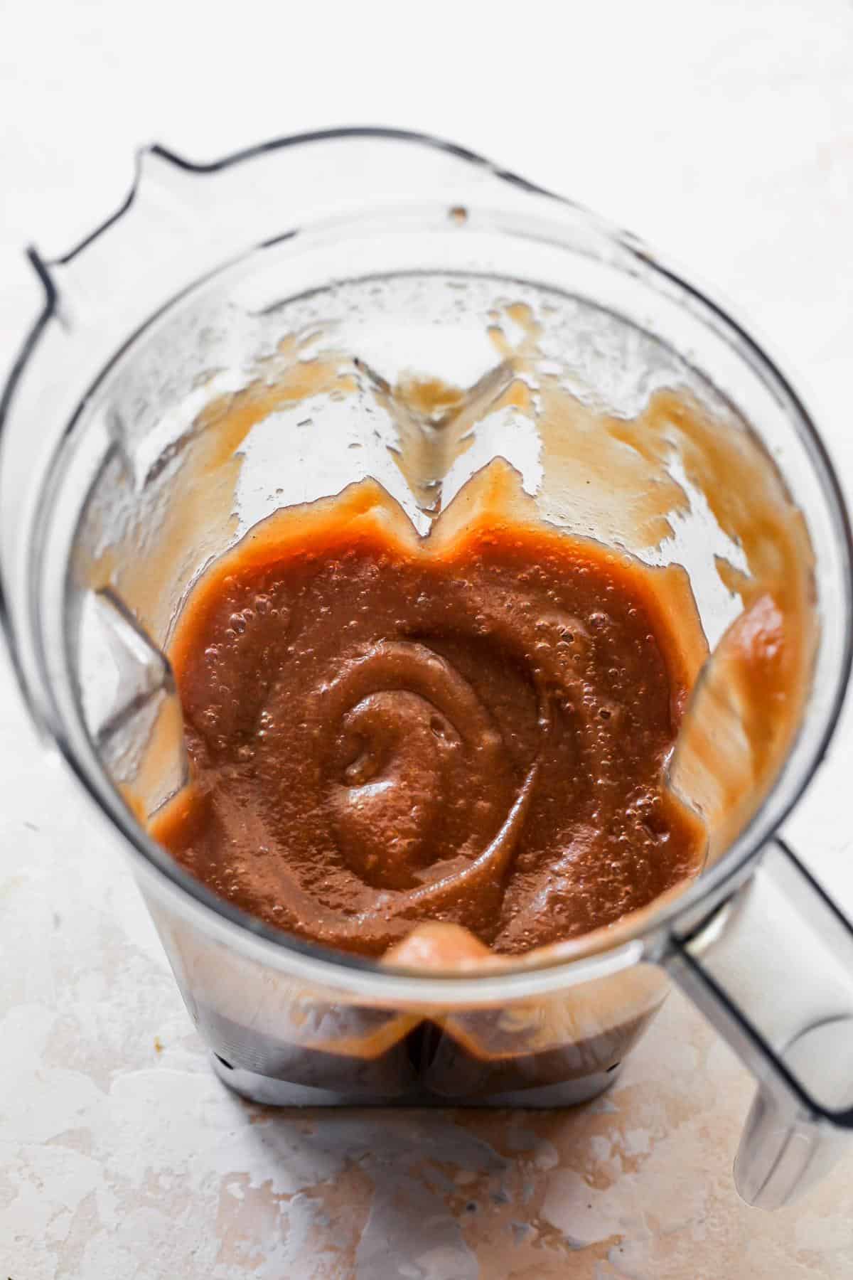 A blender with smooth, reddish-brown apple butter