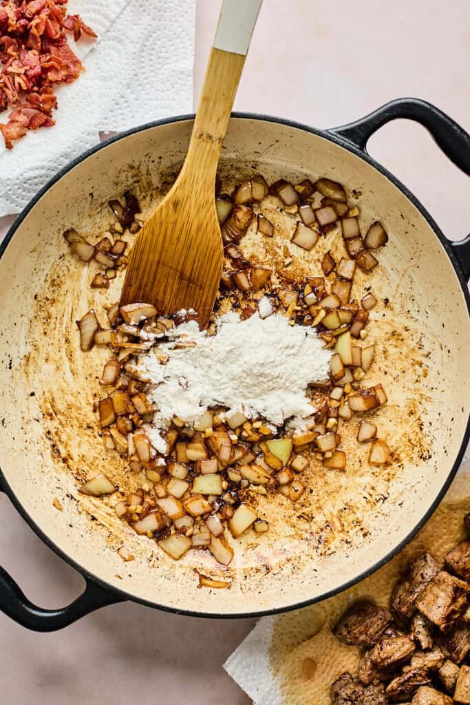 Flour being added to onions to make a gravy sauce