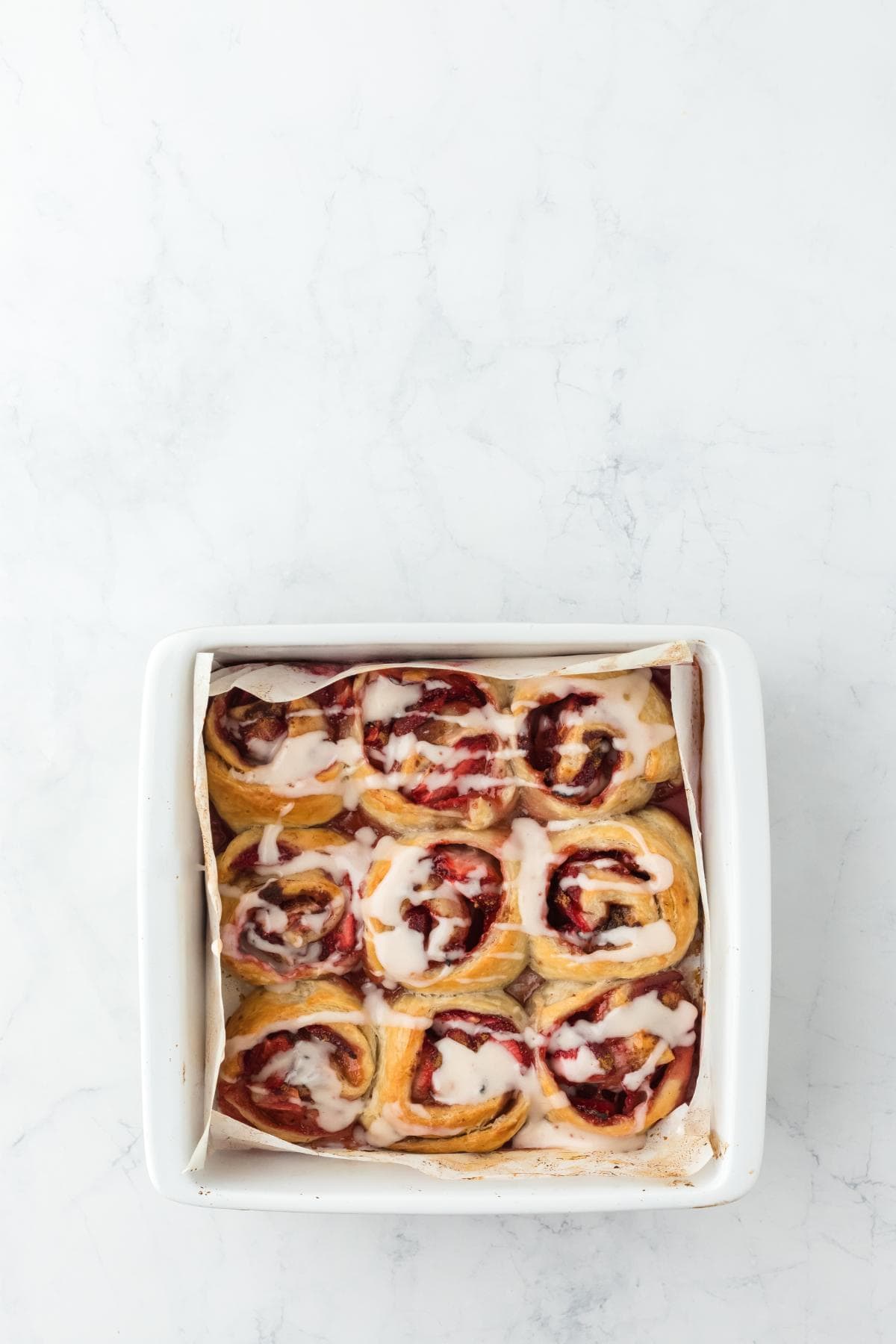 Finished strawberry cinnamon rolls fully glazed and ready to serve