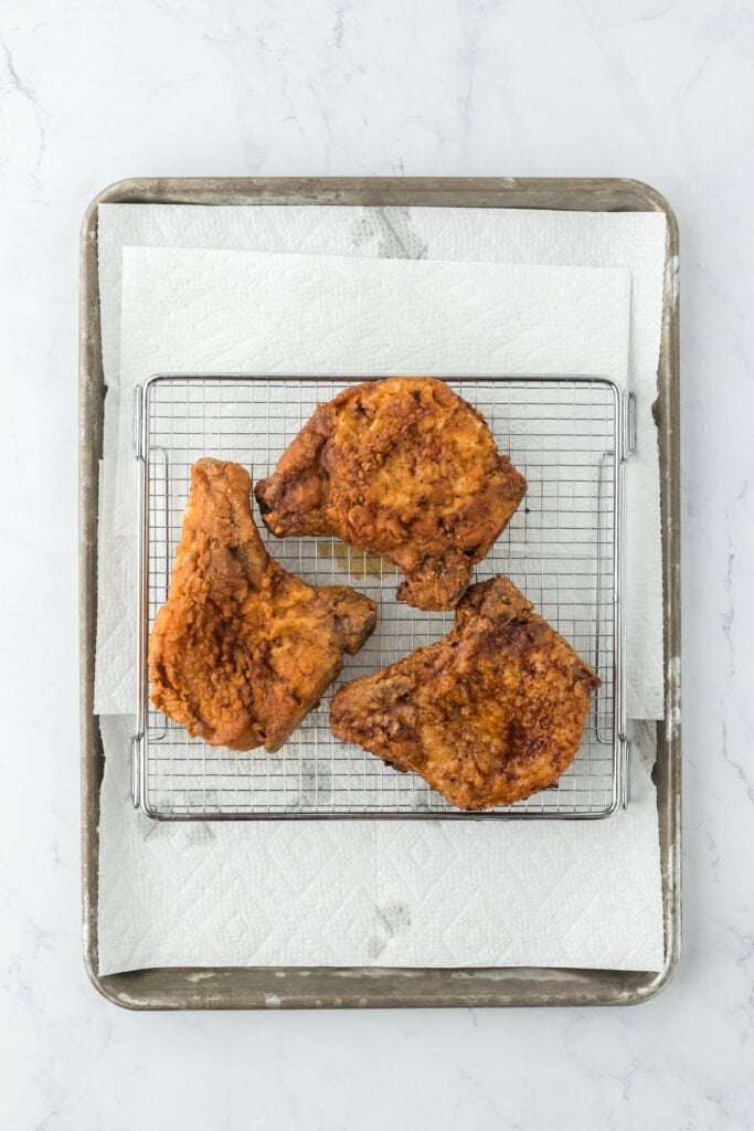 Fried pork chops on wire rack draining