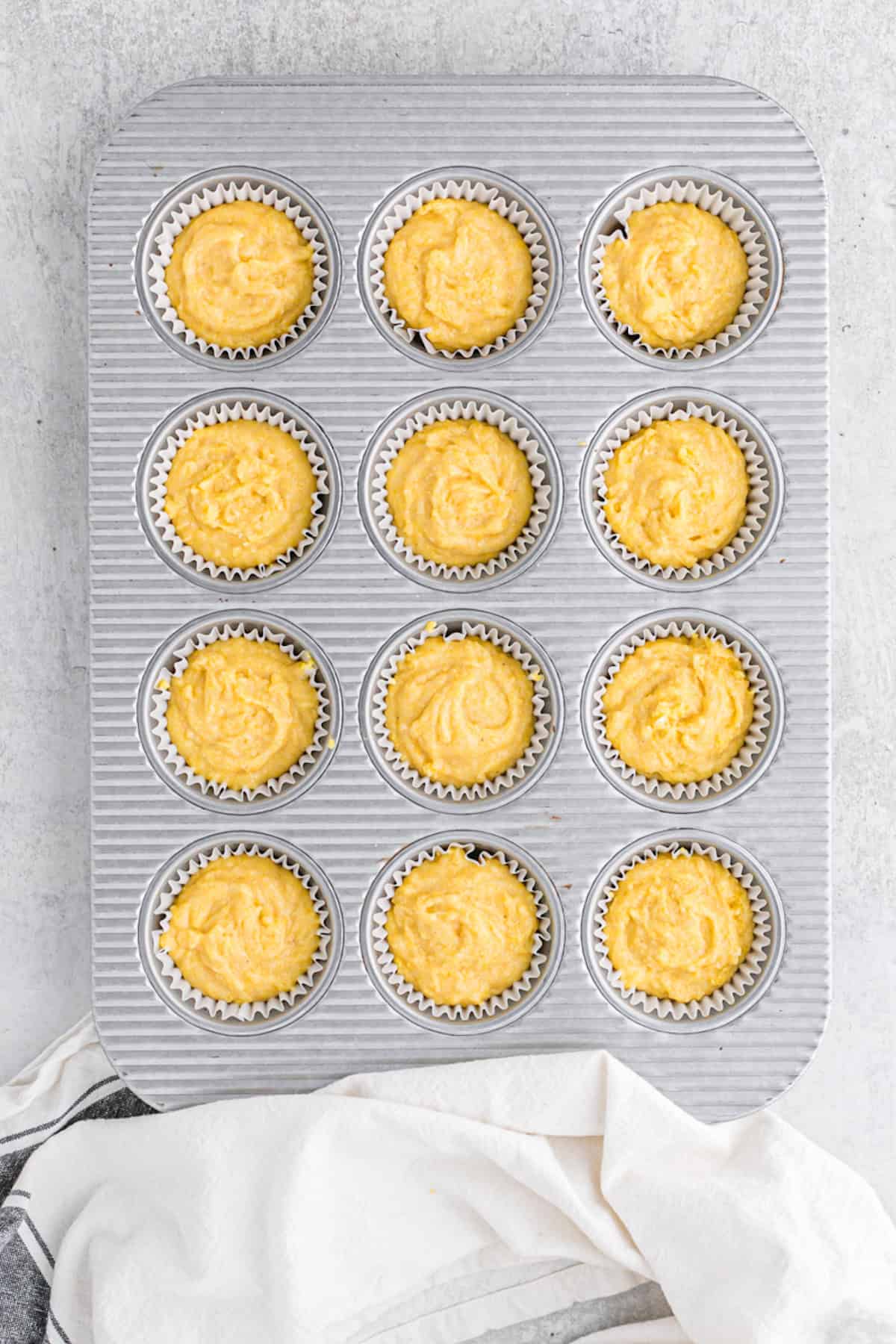 Cornbread batter added to muffin tins prior to baking