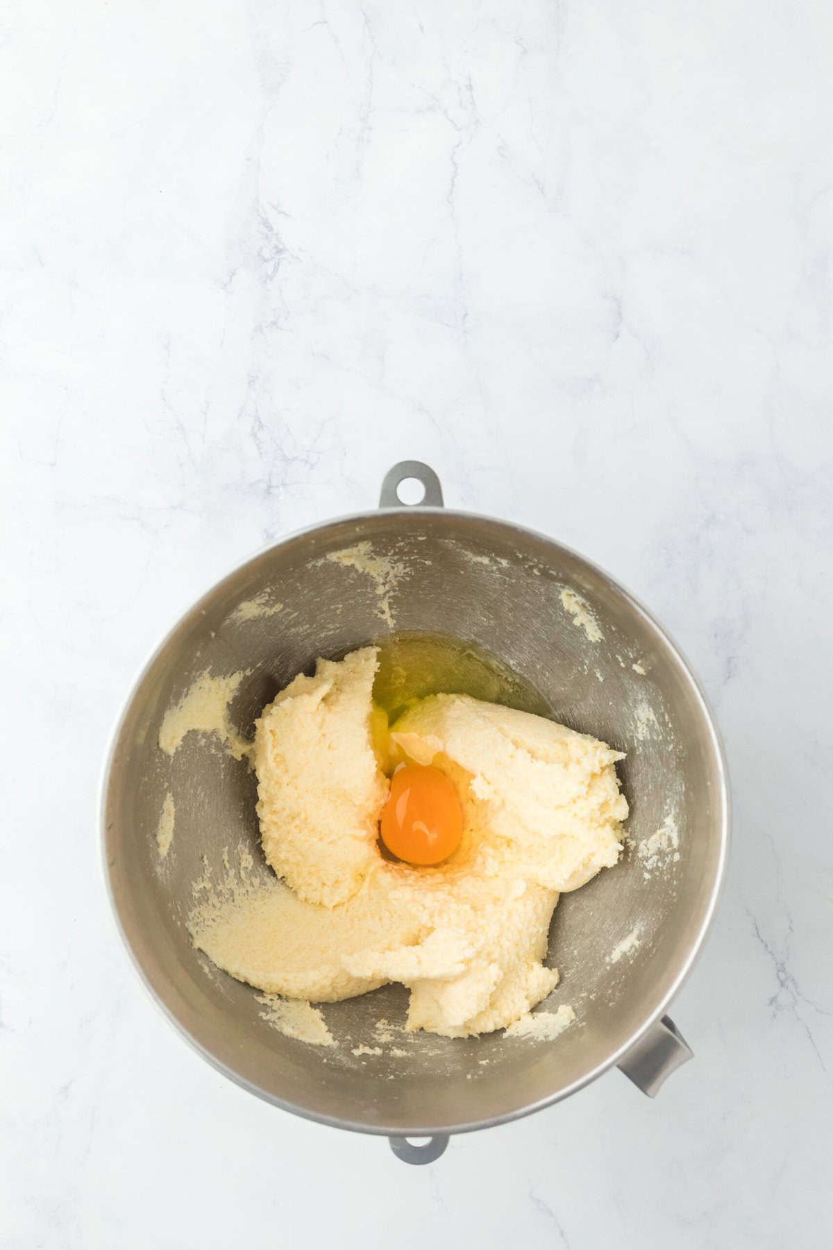 Eggs added to pie filling mixture in stand mixer bowl on white background