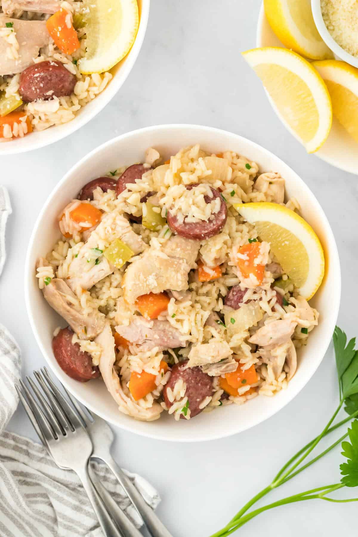 A large white bowl filled with chicken bog with a fork on the side in on a white background