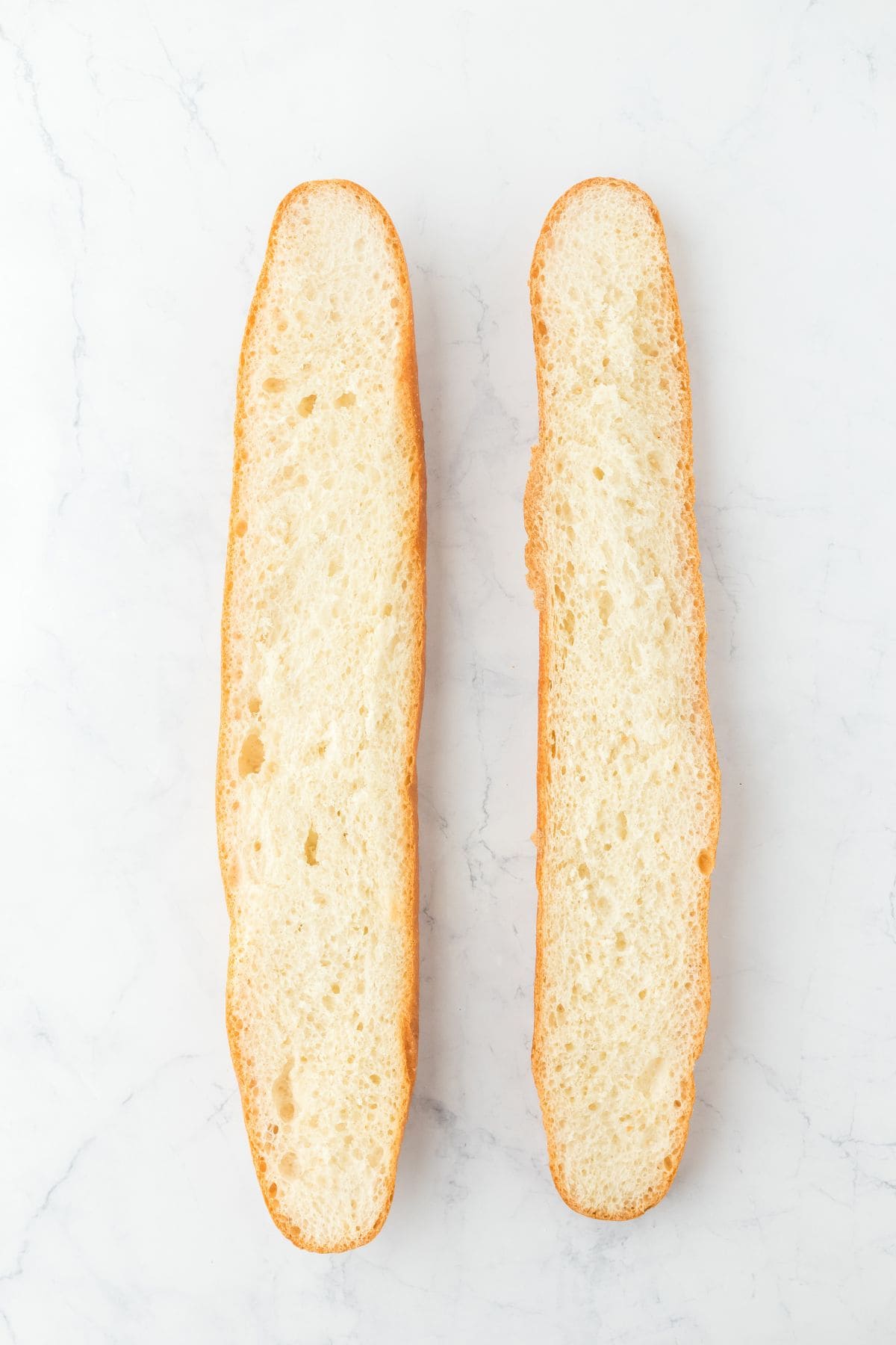 A loaf of bread sliced lengthwise, showing the inside of each half