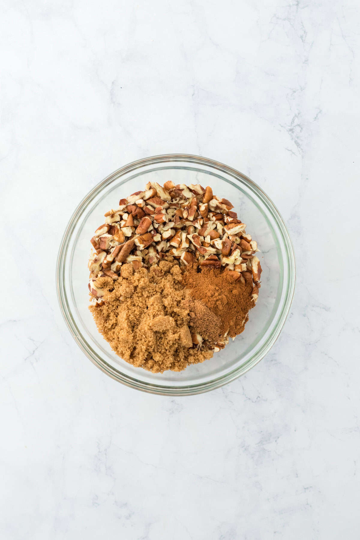 Pecan brown sugar mixture in clear glass bowl on white background