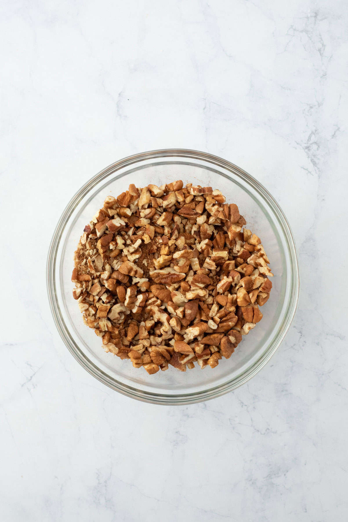 Mixed up brown sugar pecan mixture in clear bowl on white background