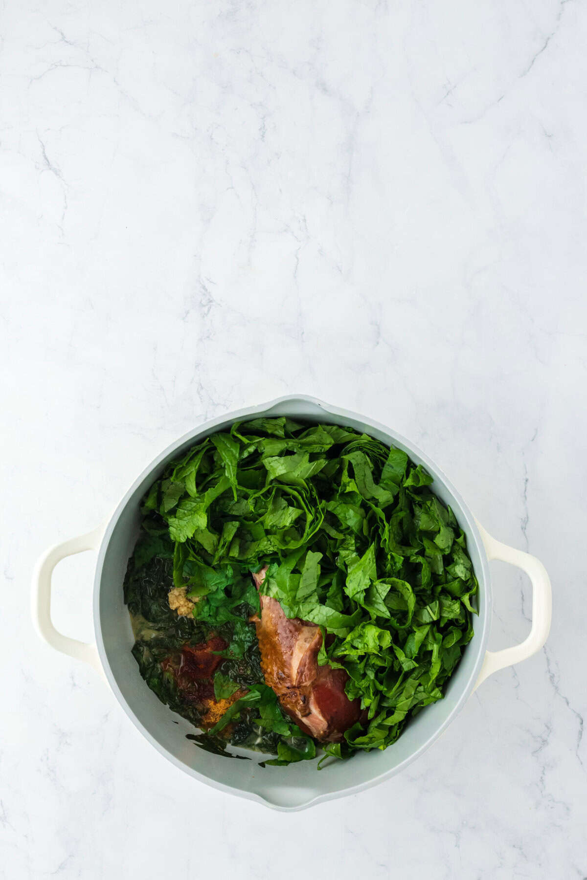 Greens in pot with turkey leg on white background