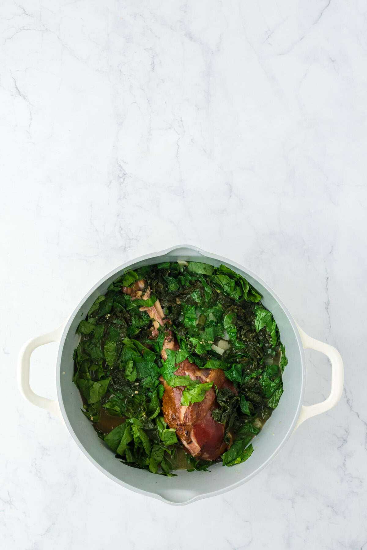 Greens all stirred together cooking in a pot