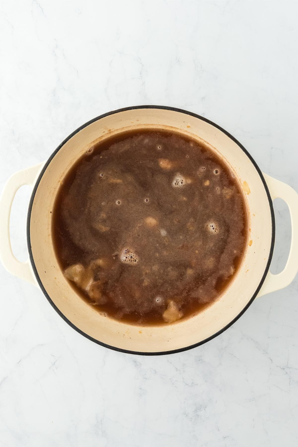 Broth added to the pot, forming the base of the stew before simmering