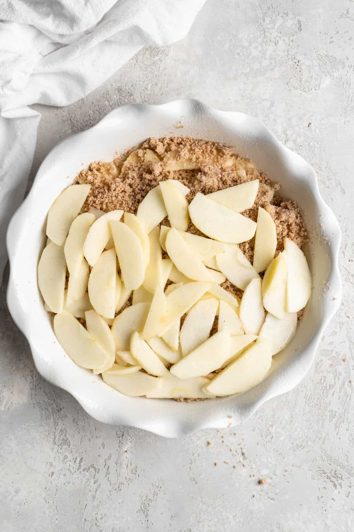 Apple slices added over brown apple betty before baking