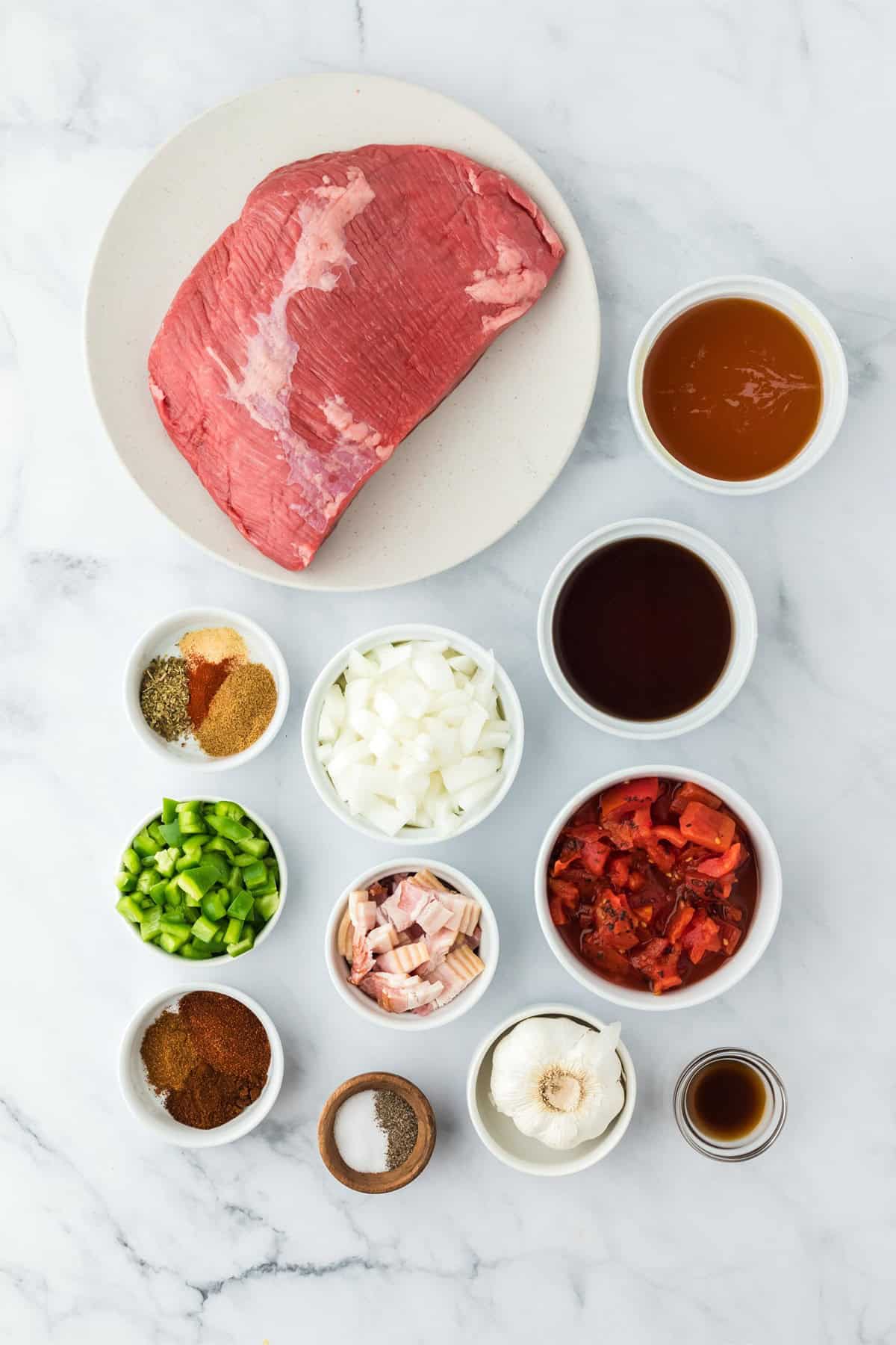 Overhead shot of ingredients to make brisket chili on a marble surface before cooking