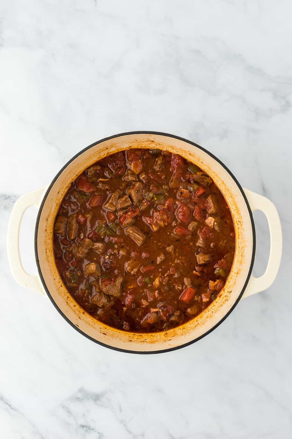 A Dutch oven filled with rich, simmering brisket chili