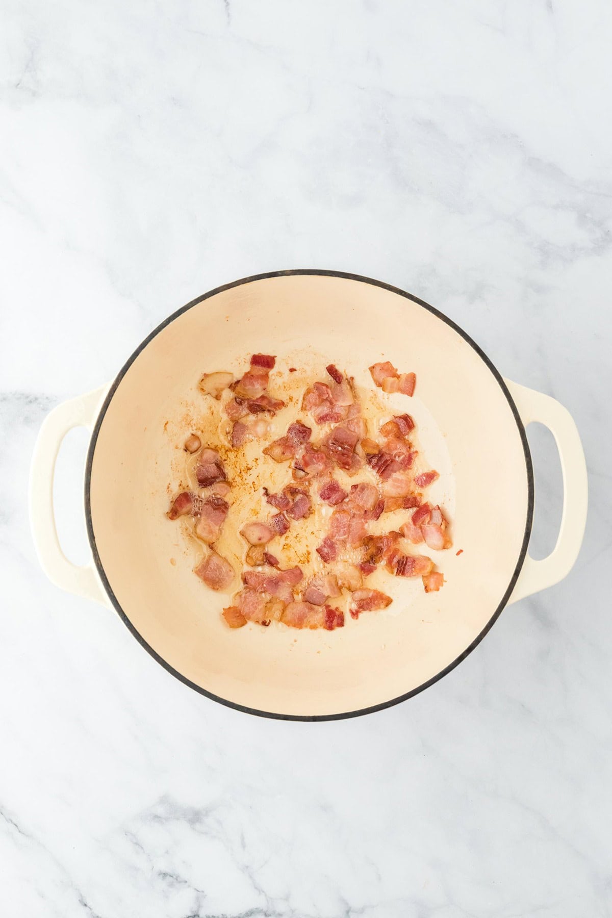 Bacon pieces rendered and slightly browned in the Dutch oven