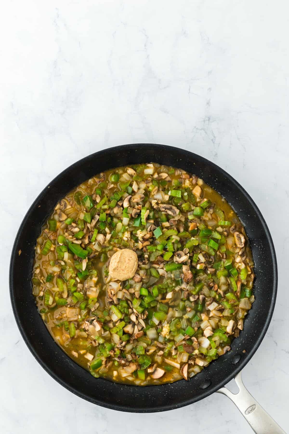 broth added to a skillet of softened vegetables