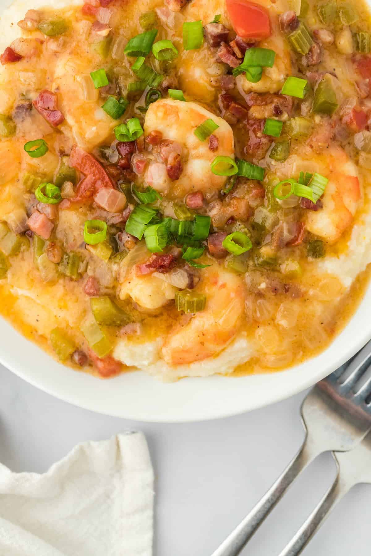 A large close up of grits and shrimp on white countertop