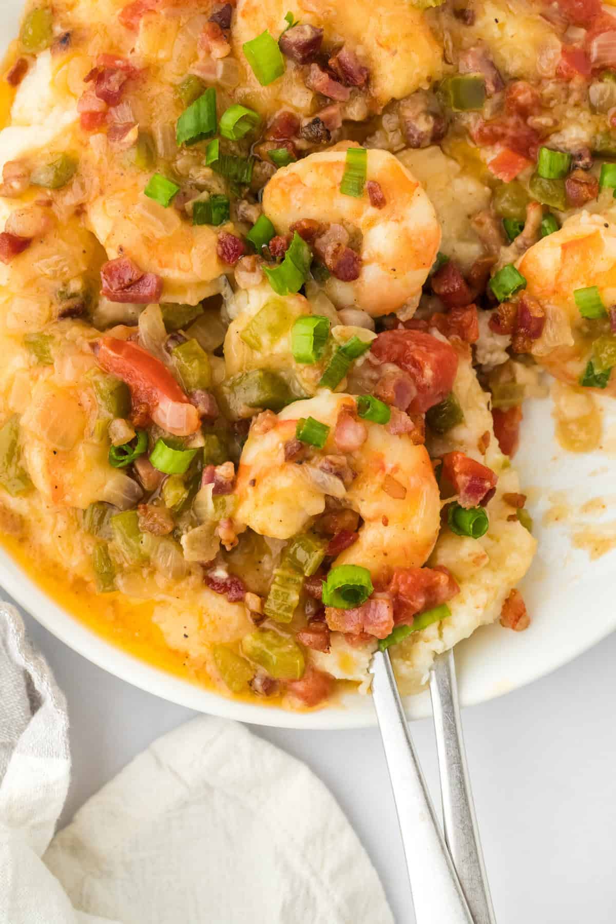 Easy Shrimp with Grits being dug into with spoons to eat on white countertop