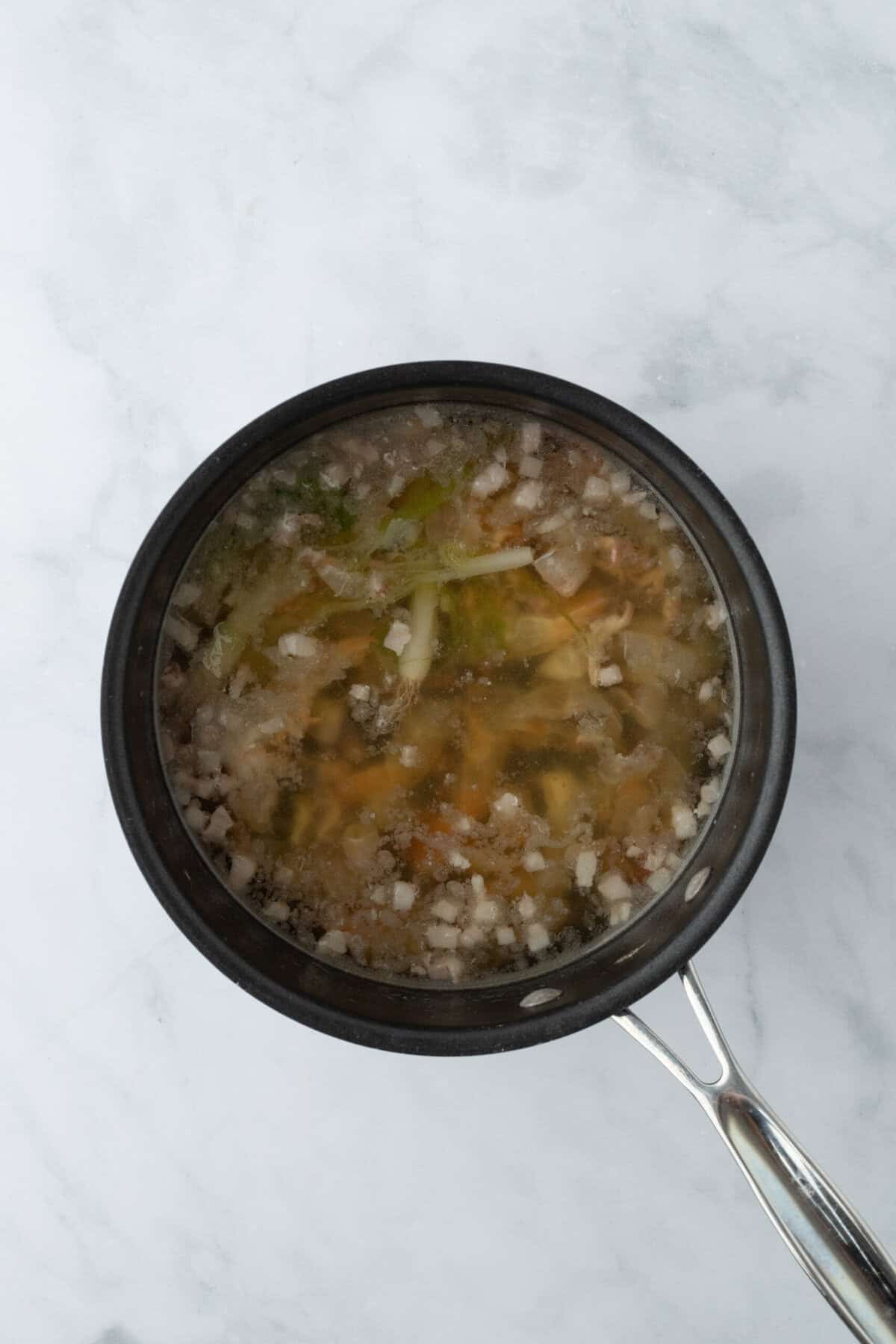 Shrimp stock boiling in a pot on white countertop