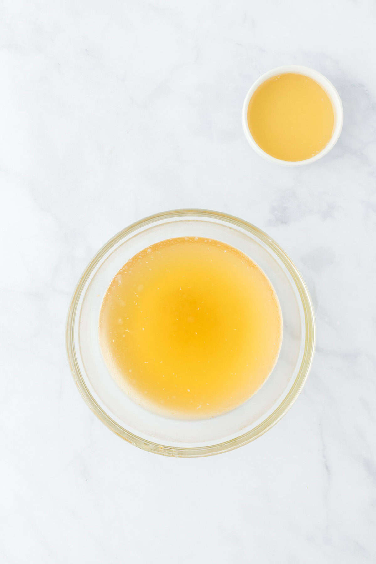 Shrimp stock reserved with some set aside on a white countertop.