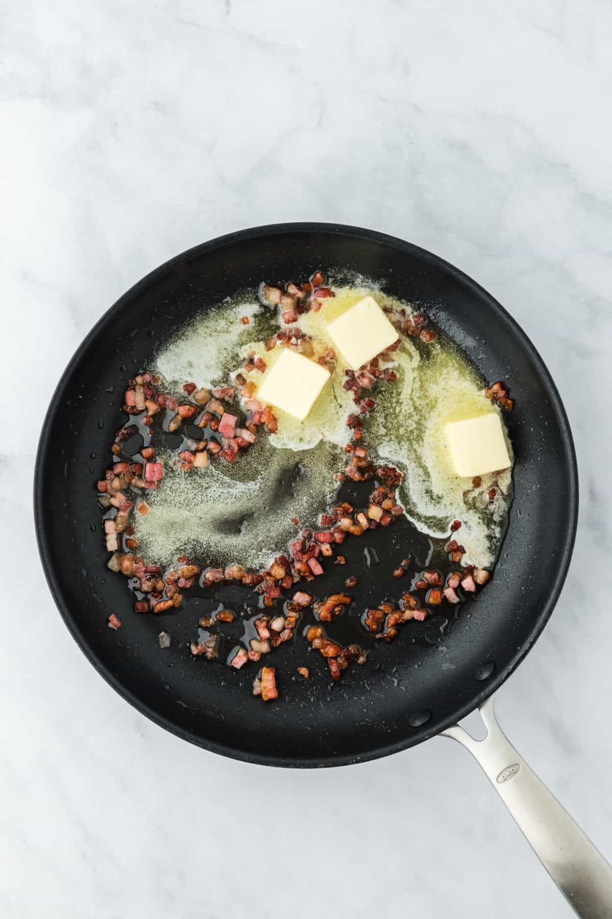 Butter and crispy pancetta in a pan being cooked