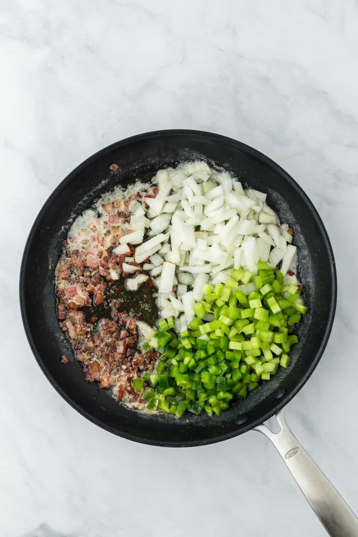 Onion, celery and bell pepper added to pan to cook.