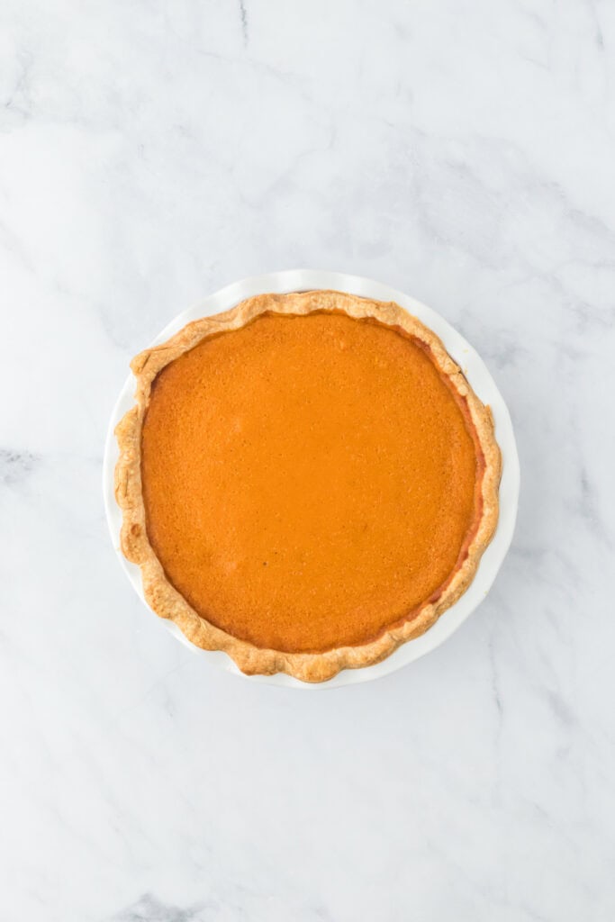 Baked sweet potato pie recipe on white countertop out of the oven