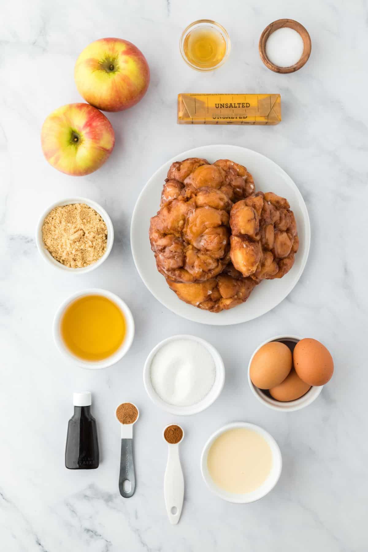 Overhead shot of ingredients to make apple fritter bread pudding on the table before baking