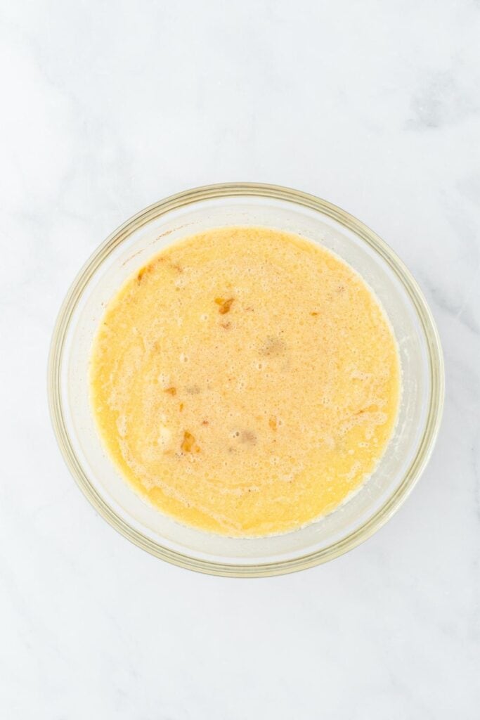 Mixed wet ingredients for bread pudding in a bowl.