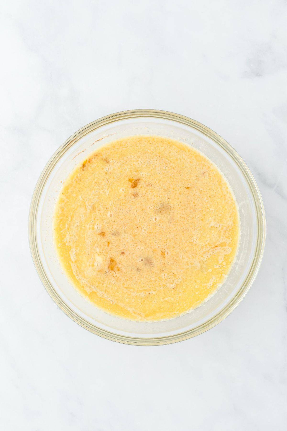 Mixed wet ingredients for bread pudding in a bowl.