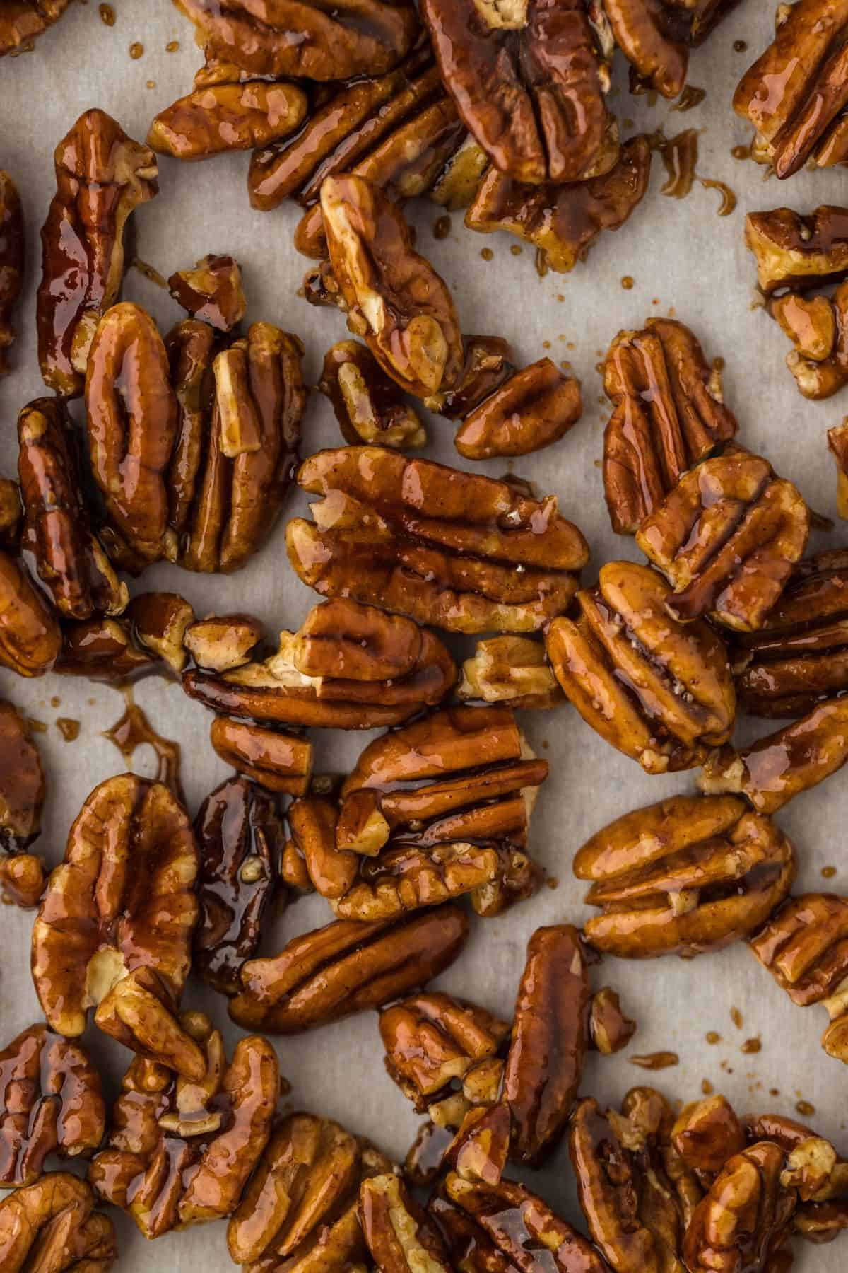 Closeup shot of glazed candied pecans on parchment paper